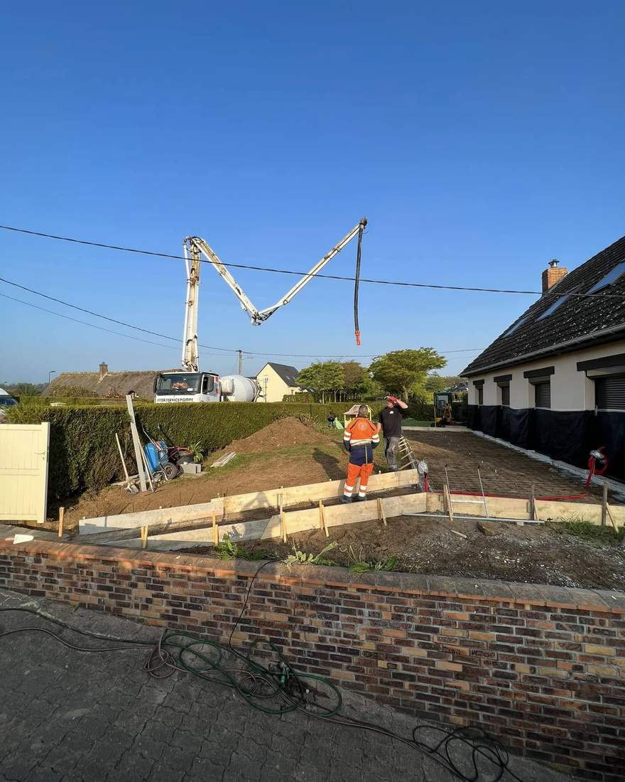 Coffrage et ferraillage d'une dalle de terrasse, avec un camion pompe à béton en action