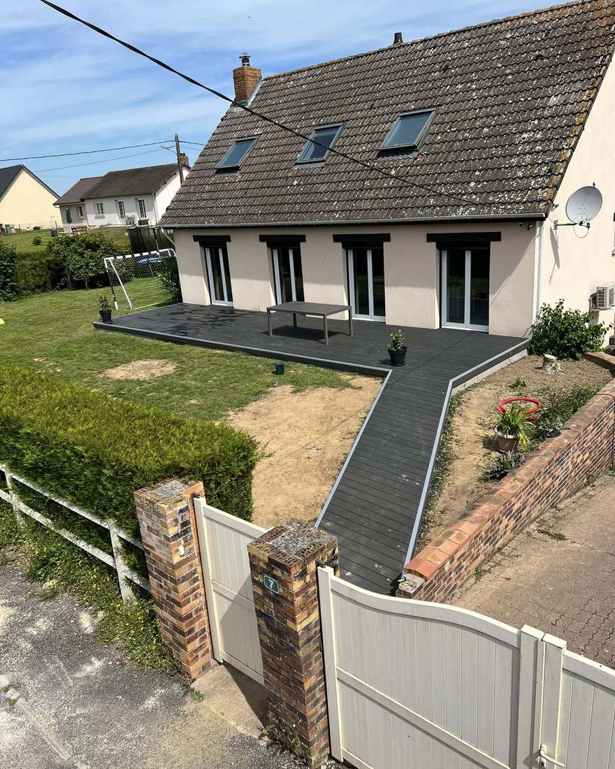 Terrasse et rampe d'accès en lames composite anthracite entre un portail et une maison